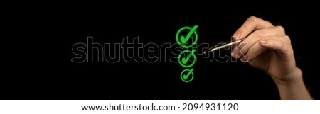 Hand marking checklist, to do and planning concept. Black background, green approved mark, business banner photo