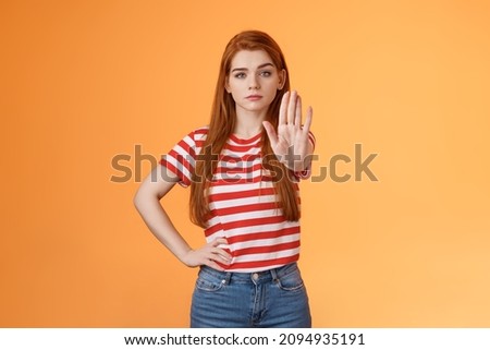 Serious-looking confident brave redhead girl oppose haters, fighting for freedom, prohibit illegal actions, extend hand stop enough, never or forbidden gesture, look determined camera Royalty-Free Stock Photo #2094935191