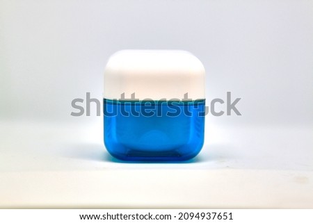 Isolated blue vial for cosmetic cream on white background, face skin care. Selective focus. High quality photo Royalty-Free Stock Photo #2094937651