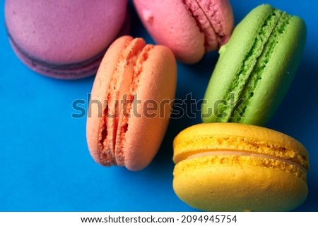 Close-up of macarons cakes of different colors in blue background. Culinary and cooking concept. Tasty colourful macaroons. Royalty-Free Stock Photo #2094945754
