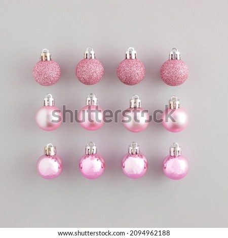 Neatly arranged pattern made of pastel pink Christmas bauble decoration. Minimal flat lay concept. Happy New Year.
