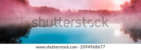 Blurred background image with foggy lake and forest landscape at sunrise
