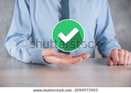 Hand holds green icon Check mark,Check Mark Sign, Tick Icon,right sign,circle green checkmark button,Done.On dark background.Banner.Copy space.Place for text