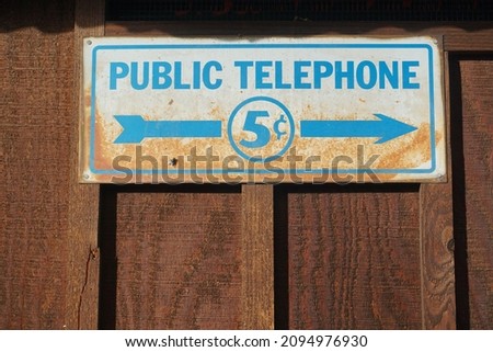 Vintage public telephone sign on aged wood boards