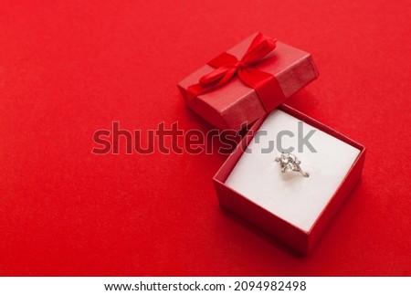 a ring with a large stone in a red box on a red background with a place for text Royalty-Free Stock Photo #2094982498