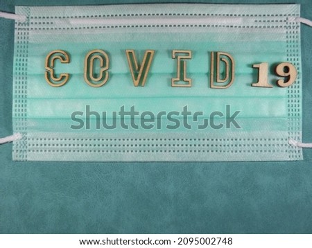 The word covid variant omicron in wooden letters on the face mask. High quality photo