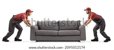 Two male workers moving a grey sofa isolated on white background Royalty-Free Stock Photo #2095012174
