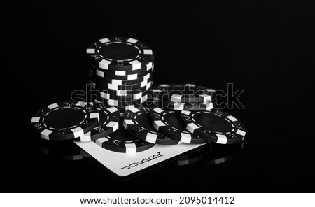 Chips and joker card on the black table in the casino. Fortune or success in the game of poker