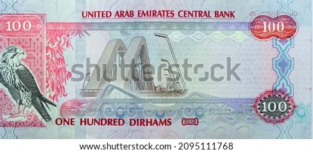 Large fragment of reverse side of 100 AED one hundred Dirhams banknote of United Arab Emirates, currency of the UAE with a picture Falcon and Sheikh Zayed Bridge series 2018, selective focus