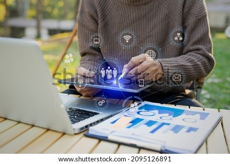 Businessman working on tablet with laptop and business financial virtual chart, Digital marketing network concept, Blurred background. 