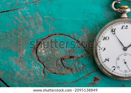 Minimalist flat lay image of clock over blue turquoise background with copy space