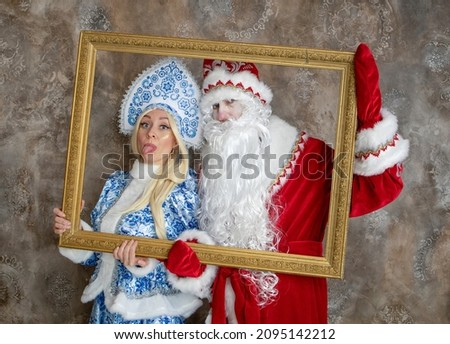 Russian Ded Moroz and Snegurochka in beautiful traditional costumes are having fun indoors. Christmas, new year, holidays, children's animation, actors. Christmas picture. Framed portrait