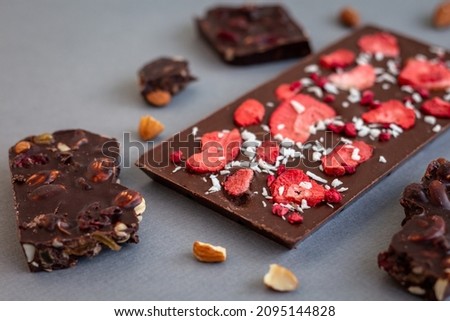 quality craft chocolate bars closeup, freeze-dried strawberry's chocolate bar among nut's chocolate pieces Royalty-Free Stock Photo #2095144828