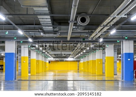 Underground parking of a commercial building with navigation system sensors. Air conditioning and ventilation ducts, fire extinguishing system pipes, electric cable channels under the ceiling.