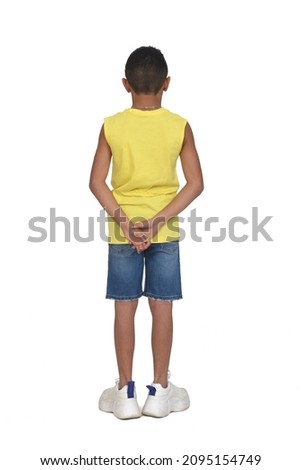 rear view of full portrait of a boy dressed in shorts and sleeveless with hands on back on white background Royalty-Free Stock Photo #2095154749