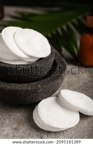 Bowl with cotton pads on grunge background, closeup