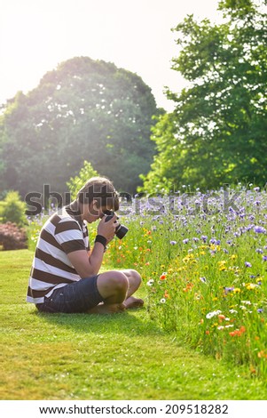 Young handsome caucasian photographer in botanic gardens