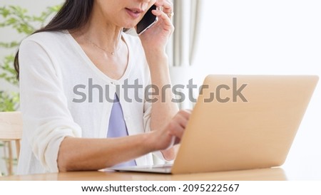 A senior woman using a computer in living room