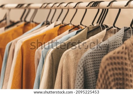 Organic eco clothes on a hanger. Home-made clothing from natural and processed fabrics, natural vegetable ingredients. Eco-friendly dresses and shirts Royalty-Free Stock Photo #2095225453