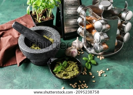Composition with tasty pesto sauce on green background
