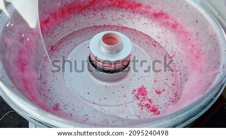 Europe, Italy , Milan December 2021  - food produced typical of the Italian culinary culture - 
at the fair a man makes pink cotton candy with candy floss machine Royalty-Free Stock Photo #2095240498