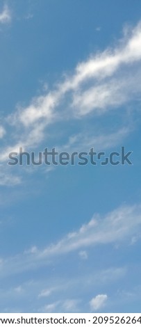 Elegant Cloudy Blue Sky texture, wallpaper background. Beautiful blue sky with soft white clouds in winter. Vertical image. Stratocumulus clouds (Small waves of fluffy clouds). Sky between the clouds