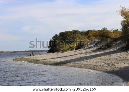 Autumn landscapes in Ukraine. Orange-green trees on the cave coast of the Dnieper River.