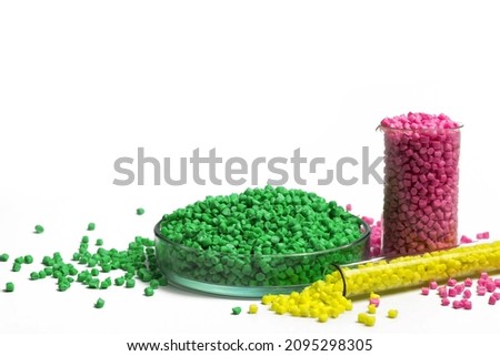 Green, yellow and pink granules of polypropylene or polyamide on a white background. Plastics and polymers industry. Copy space. Glass petri dish, flask, volumetric glassware, test tube. Royalty-Free Stock Photo #2095298305