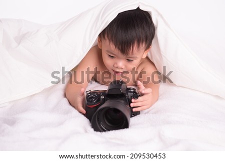 Baby Boy holding professional camera and taking photo