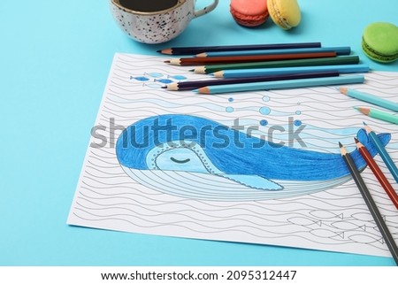 Coloring picture, cup of coffee and pencils on table
