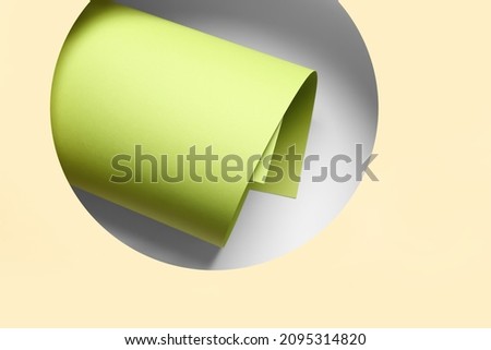Composition with rolled paper sheet on color background