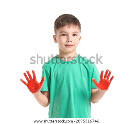 Little boy with hands in paint on white background