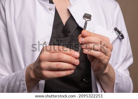 a male doctor in a white coat holding a manual therapy roller. High quality photo