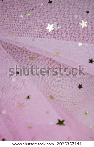 Light pink Crumpled festive tulle fabric (pink, purple, delicate) with sequins in the form of stars drapes beautifully. texture of wedding clothes, veil, dress, skirt.