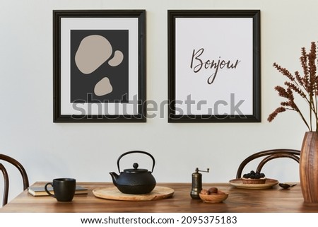 Stylish composition of modern kitchen interior design with mock up poster frames, black console, teapot and kitchen accessories. Template. Autumn vibes.
