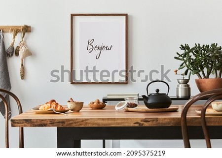 Stylish composition of cozy dining room intrerior with mock up poster frame, wooden family dining table, plants and vintage personal accessories. Copy space. Template. Autumn vibes.
