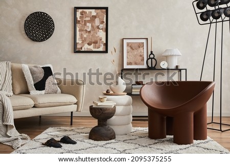 Elegant interior of living room with beige sofa, black console, brown creative armchair, industrial lamp, mock up poster frame and stylish home decorations. Copy space. Template.