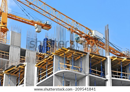 Crane and building construction site against blue sky Royalty-Free Stock Photo #209541841