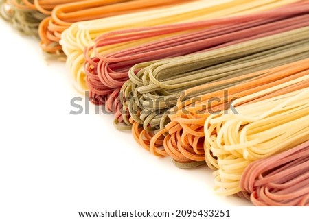The heap of Italian vegetable flat pasta on white background. Horizontal view. Closeup picture.