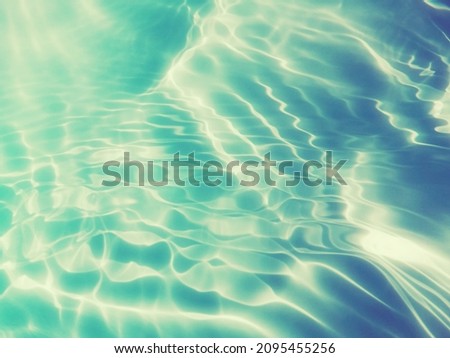 Closeup​ blur​ abstract​ of​ surface​ blue​ water for​ background. Abstract​ of​ surface​ blue​ water​ reflected​ with​ sunlight​ for​ graphic​ design.Top​ view​ of blue​ water​ for​ background.
