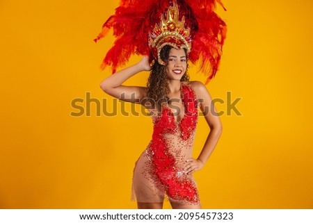 Brazilian afro woman posing in samba costume over yellow background with free space. Brazilian dressed Samba costume.