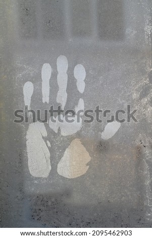 Handprints on the cold glass of the window.