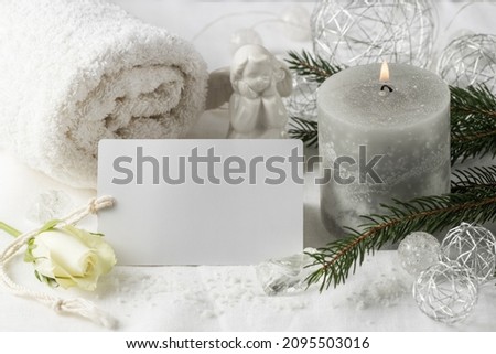 Spa wellness winter  blank card mockup with burning candle,  towel, chtristmas tree twig and decorative angel on white linen background