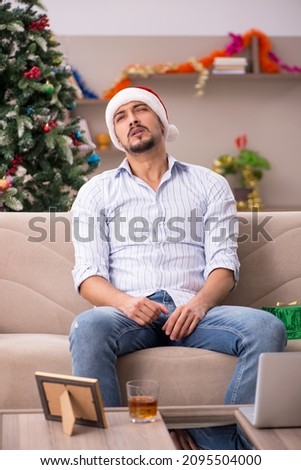 Young man celebrating Christmas at home alone