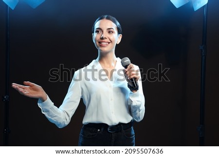 Motivational speaker with microphone performing on stage Royalty-Free Stock Photo #2095507636