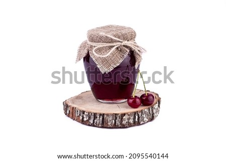 Natural wooden podium with jam and fresh cherry on white background.