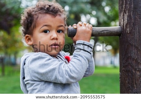 2 year old Jamaican English Italian toddler playing with playground apparatus