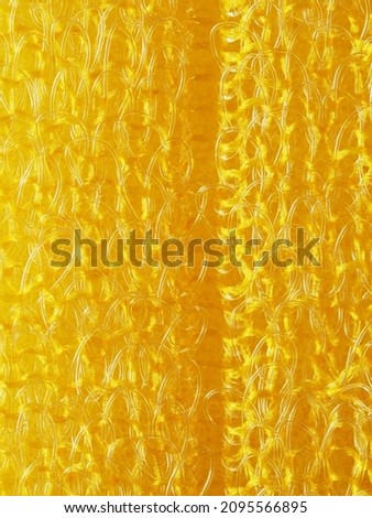 close up, background, texture, large vertical banner. heterogeneous surface structure bright saturated yellow sponge for washing dishes, kitchen, bath. full depth of field. high resolution photo