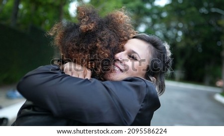 Two young women embrace. diverse friendship genuine hug