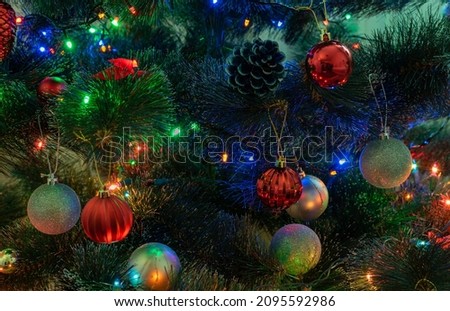 Multicolored balls on decorated christmas tree close-up with reflection of colored light bulbs garland Royalty-Free Stock Photo #2095592986